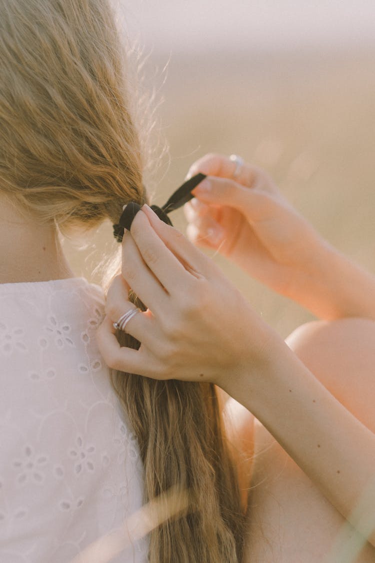 Hands Of A Woman Tying A Ponytail