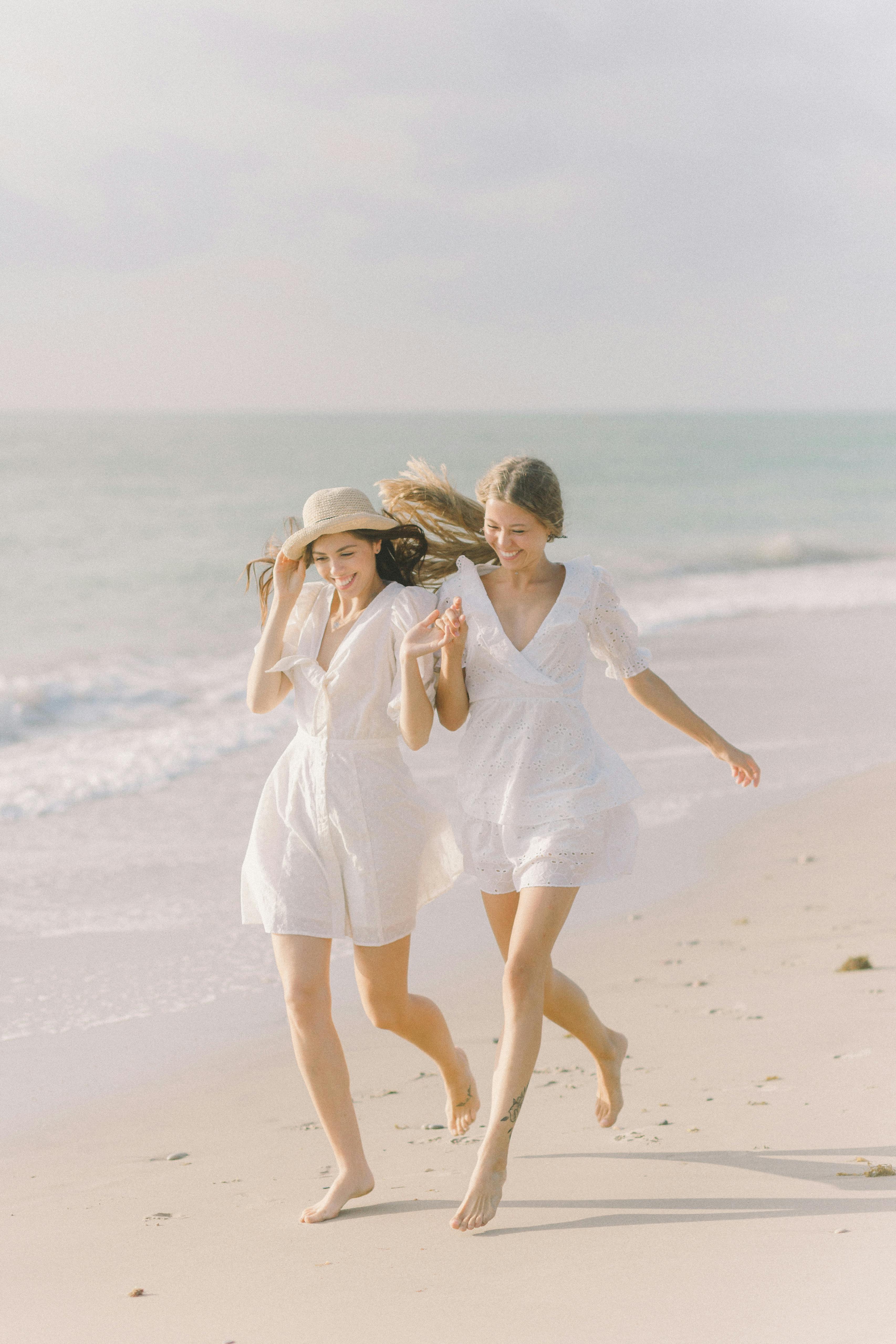 couple holding hands while running on the sand