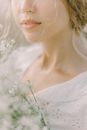 一名穿着白色蕾丝衬衫、开着白花的女人的特写