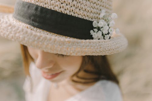 A Woman Wearing a Hat with White Flowers