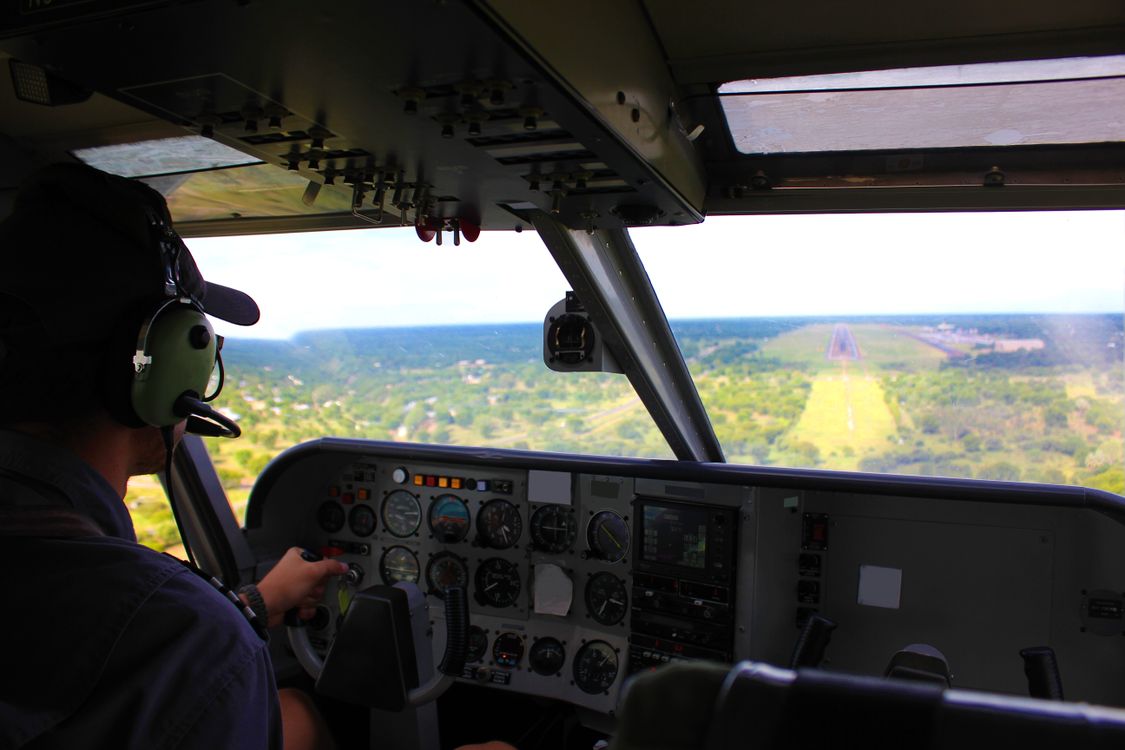 Pilot in cockpit flying a commercial airplane with instrument panel visible