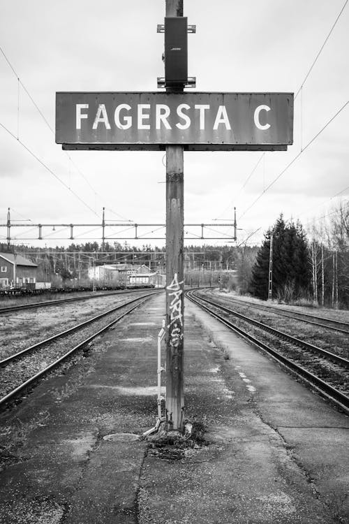Grayscale Photo of Rail Road Sign