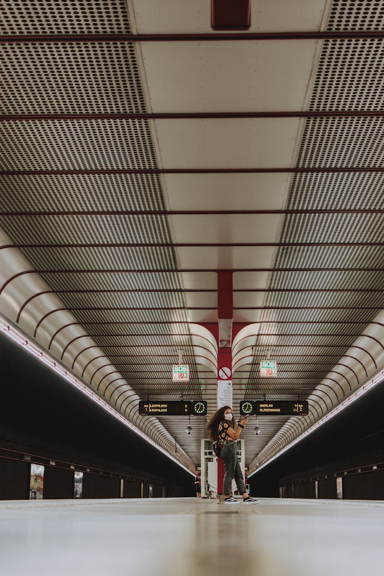 Female Passenger With Mask Waiting For Train