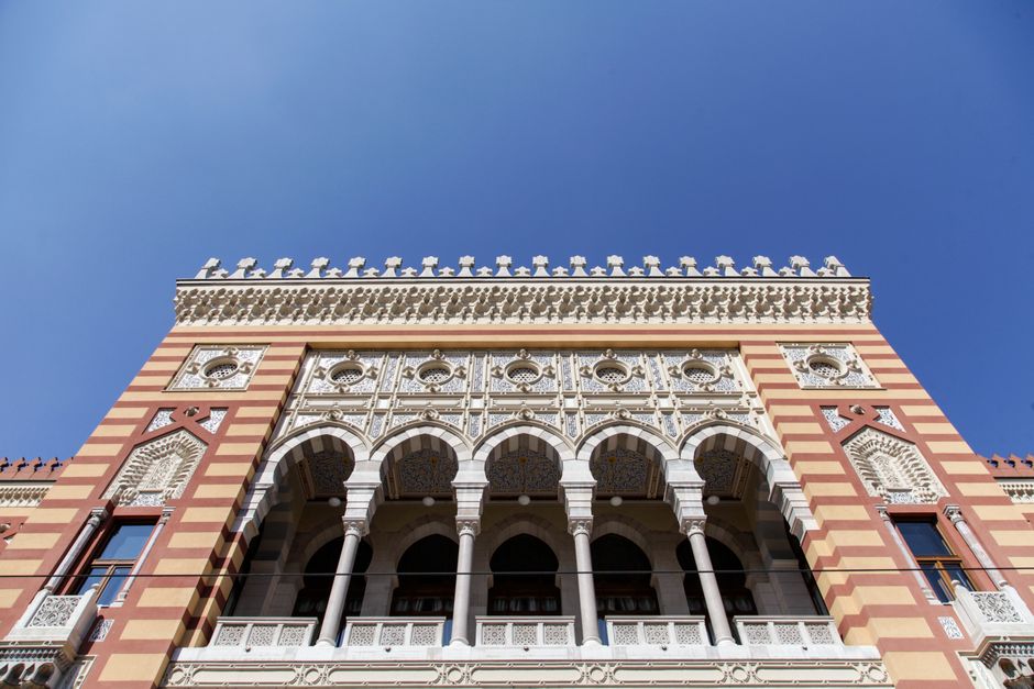 Ornate facade of Sarajevo City Hall showcasing historic architecture against a clear blue sky.