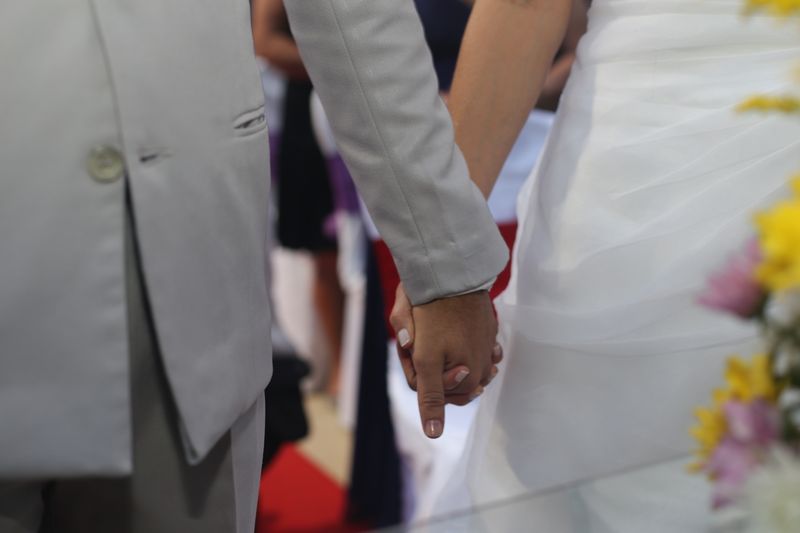 Close-up of wedding couple holding hands