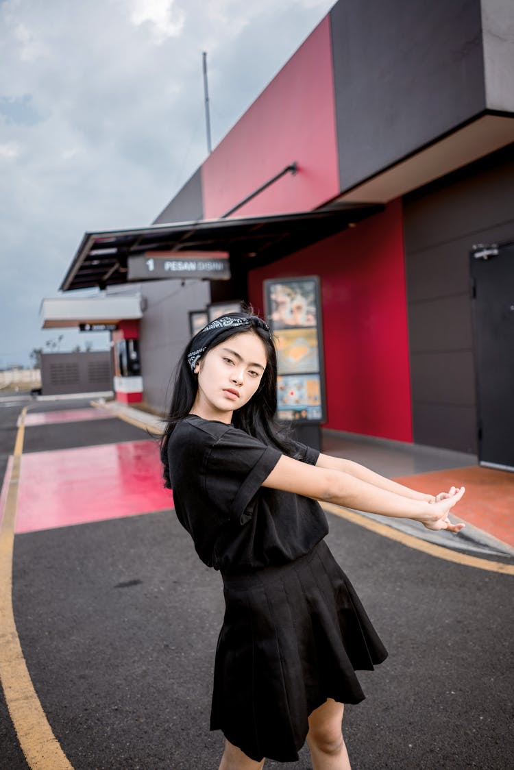 Stylish Asian Young Woman Relaxing On Street On Cloudy Day