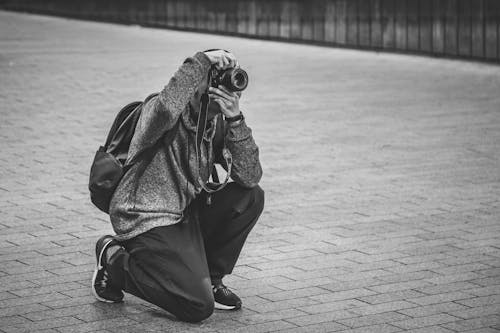 Grayscale Photo of Man Taking Photo with a Camera