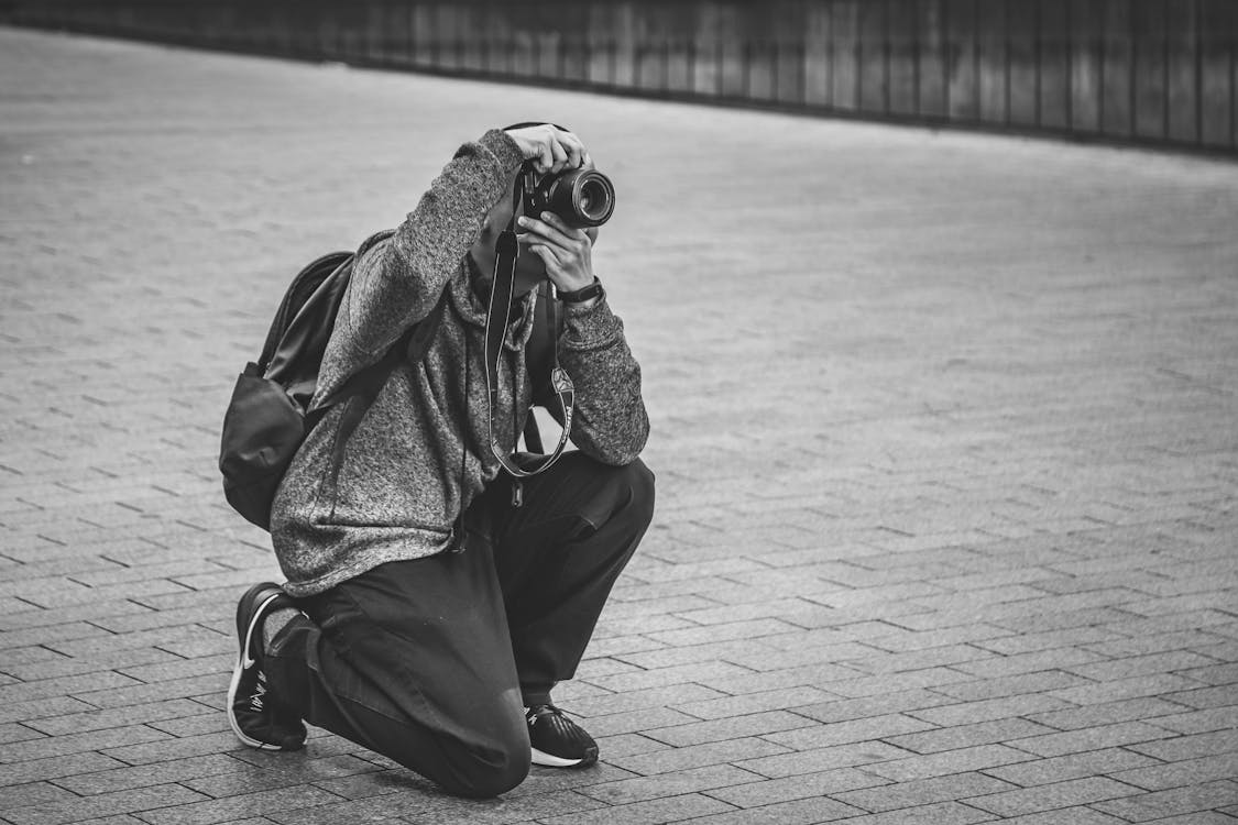 Grayscale Photo of Man Taking Photo with a Camera