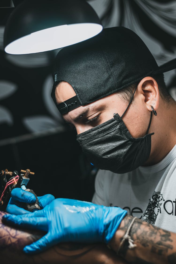 Tattooist Drawing On Arm In Salon