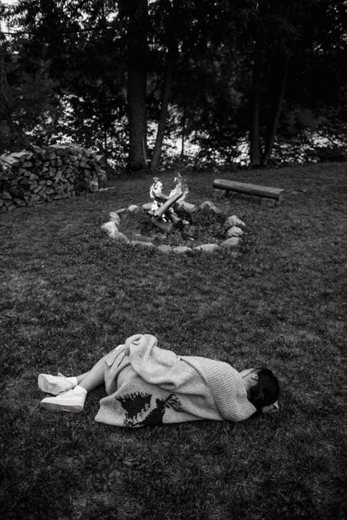 Woman lying near bonfire in forest · Free Stock Photo