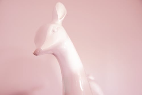 White Ceramic Deer Figurine on Pink Background