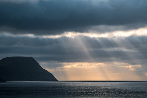 Free Sunrays Peeking Through Dark Clouds Stock Photo