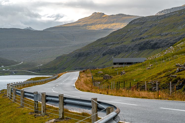 Highway Going Through Mountains By Lake