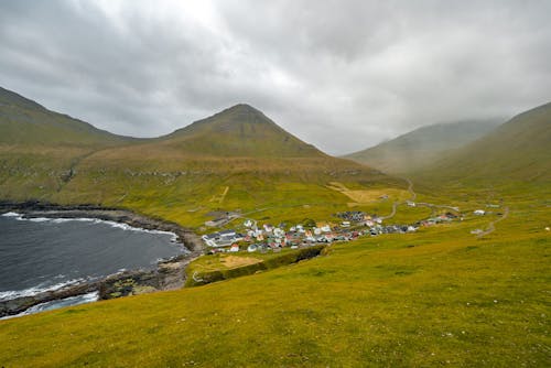 Village in a Valley Between Green Hills and Mountains 