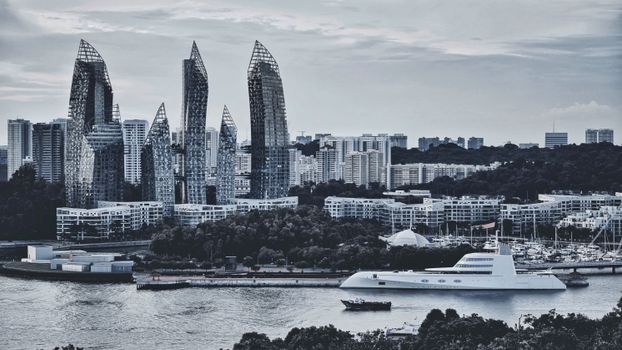 Contemporary skyline with unique skyscrapers by the river and a luxury yacht, showcasing urban architecture.