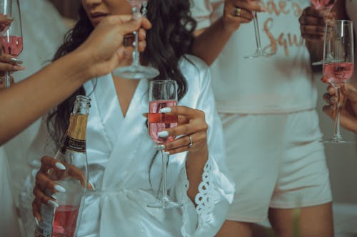 Woman in White Robe Holding Clear Glass with Wine