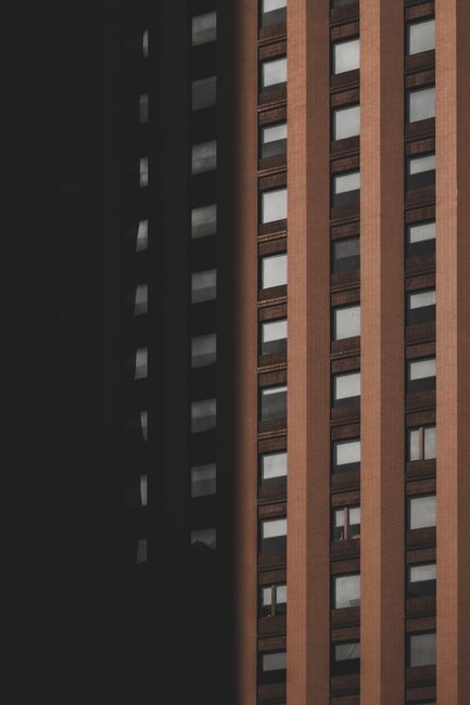 Close-up shot of a multi-storey building's facade with vertical elements and glass windows.