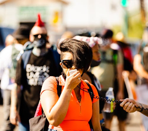 Woman Wearing Black Sunglasses Speaking on a Microphone