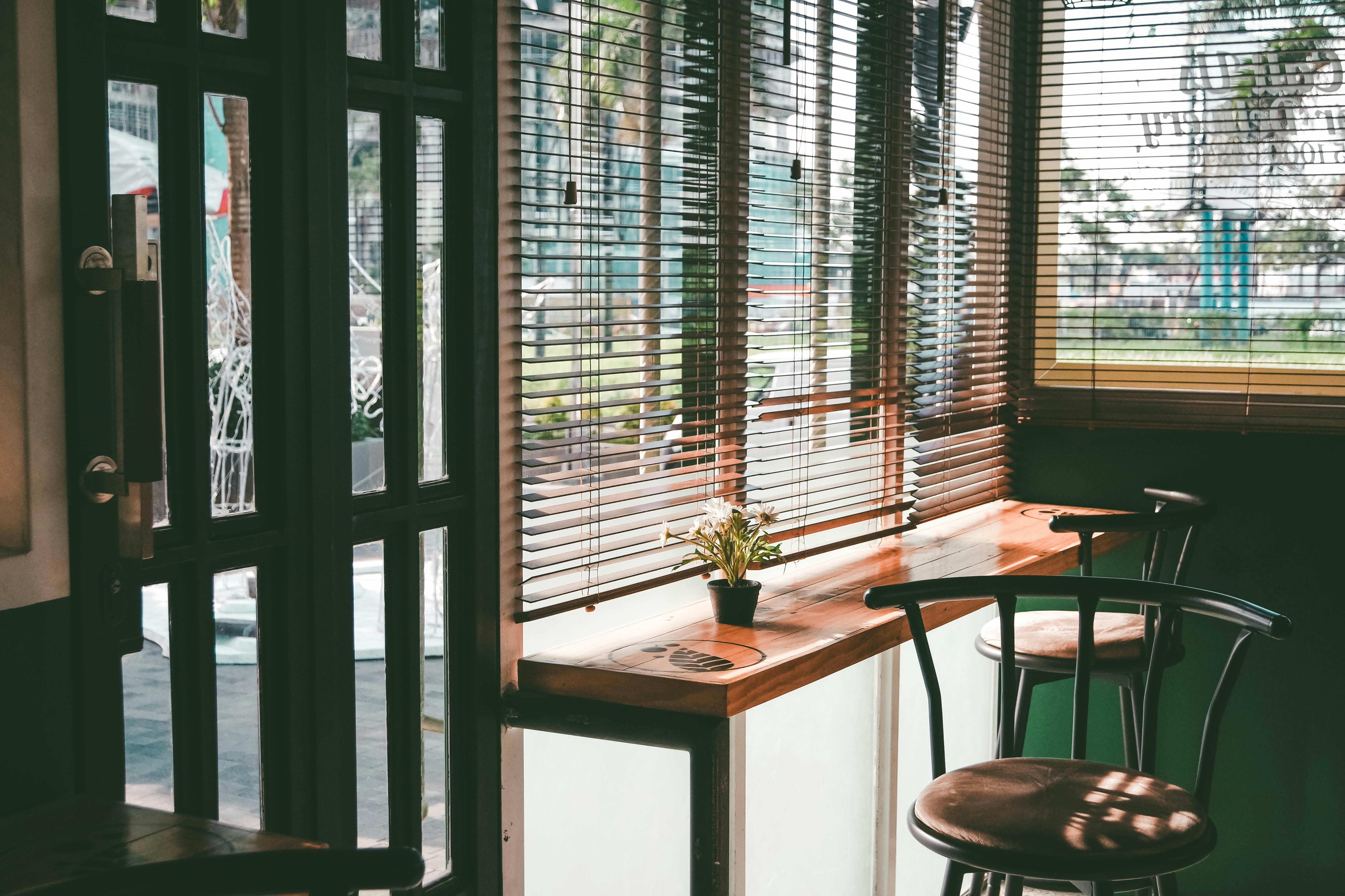 two steel framed bar stools in front of window with blinds