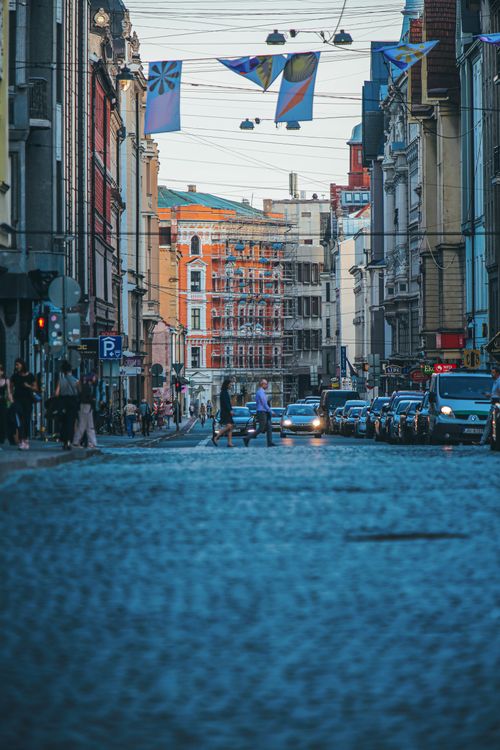 Free A bustling cobblestone street in Riga, Latvia, featuring historic architecture and pedestrians at dusk. Stock Photo
