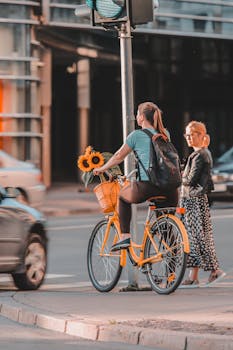 Woman on a bicycle with sunflowers waiting at a crosswalk in Riga, Latvia.