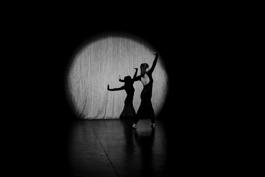Female dancer performing on stage under spotlight