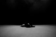 一张艺术照片中，芭蕾舞演员躺在极简主义的黑暗环境里