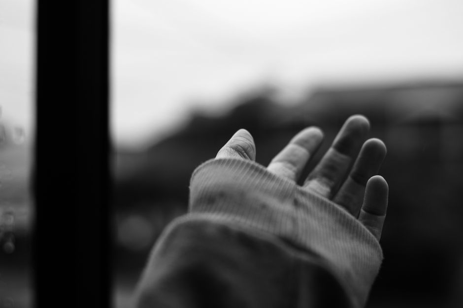 Black and white photo of a hand reaching out, creating a sense of longing and connection.