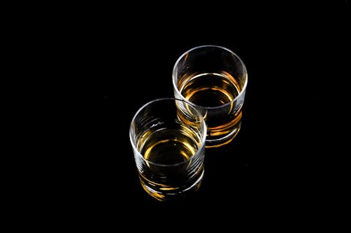 Free Two Clear Shot Glasses Filled With Liquors Stock Photo