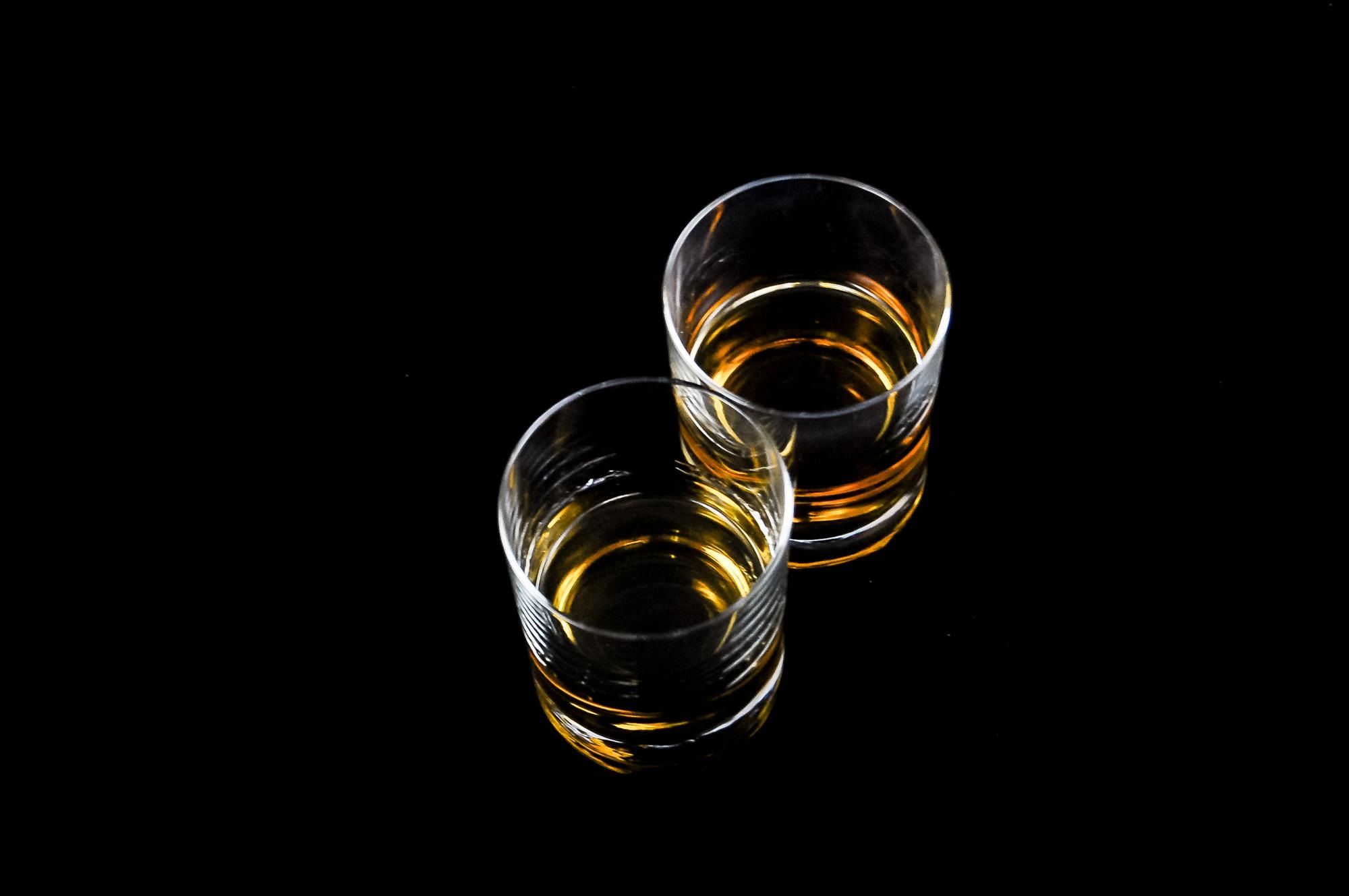 Dos vasos de whisky ámbar uno al lado del otro