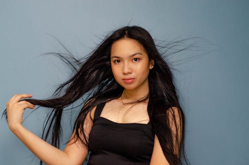 Woman in Black Tank Top Leaning on a Wall