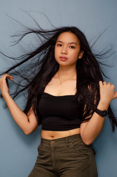 Woman Wearing Black Tank Top Holding Her Long Hair