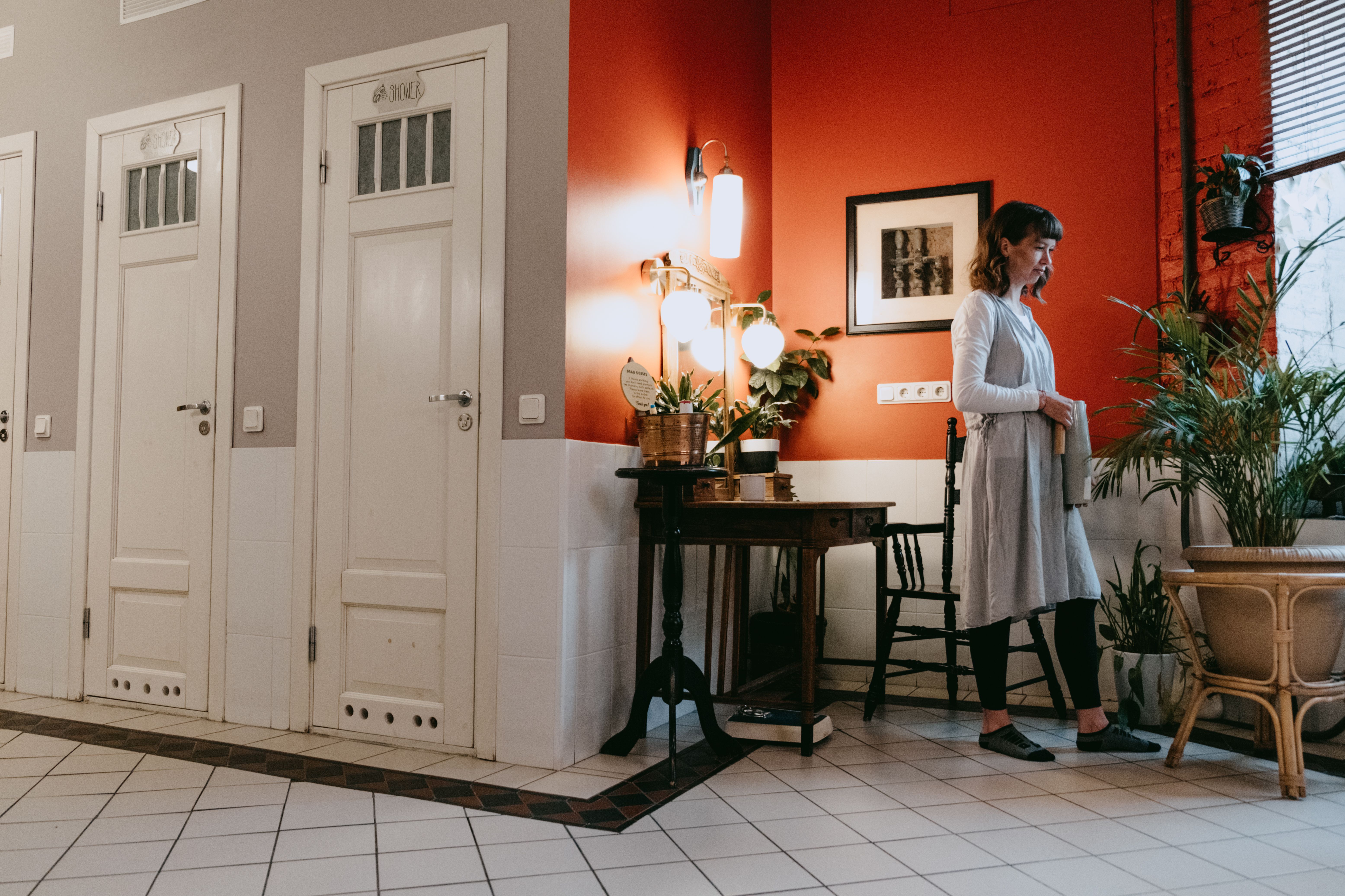 A woman enjoys a stylish room with houseplants, creating a peaceful ambiance.