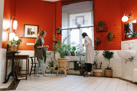 Two women tending to plants in a stylish bathroom featuring bold red walls.