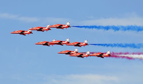 Kostenlos Red Jet Fighter Flugzeuge Mit Verschiedenen Rauchfarben Am Horizont Stock-Foto