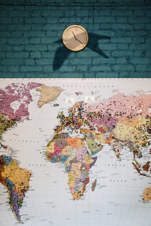 Pinned Map on Blue Wall Below a Wall Clock