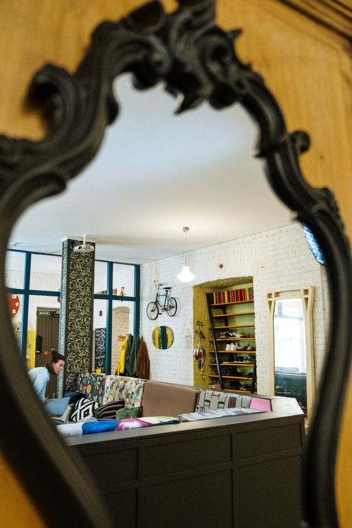 Free A modern living room with a couch and unique decor seen through an ornate mirror reflection. Stock Photo
