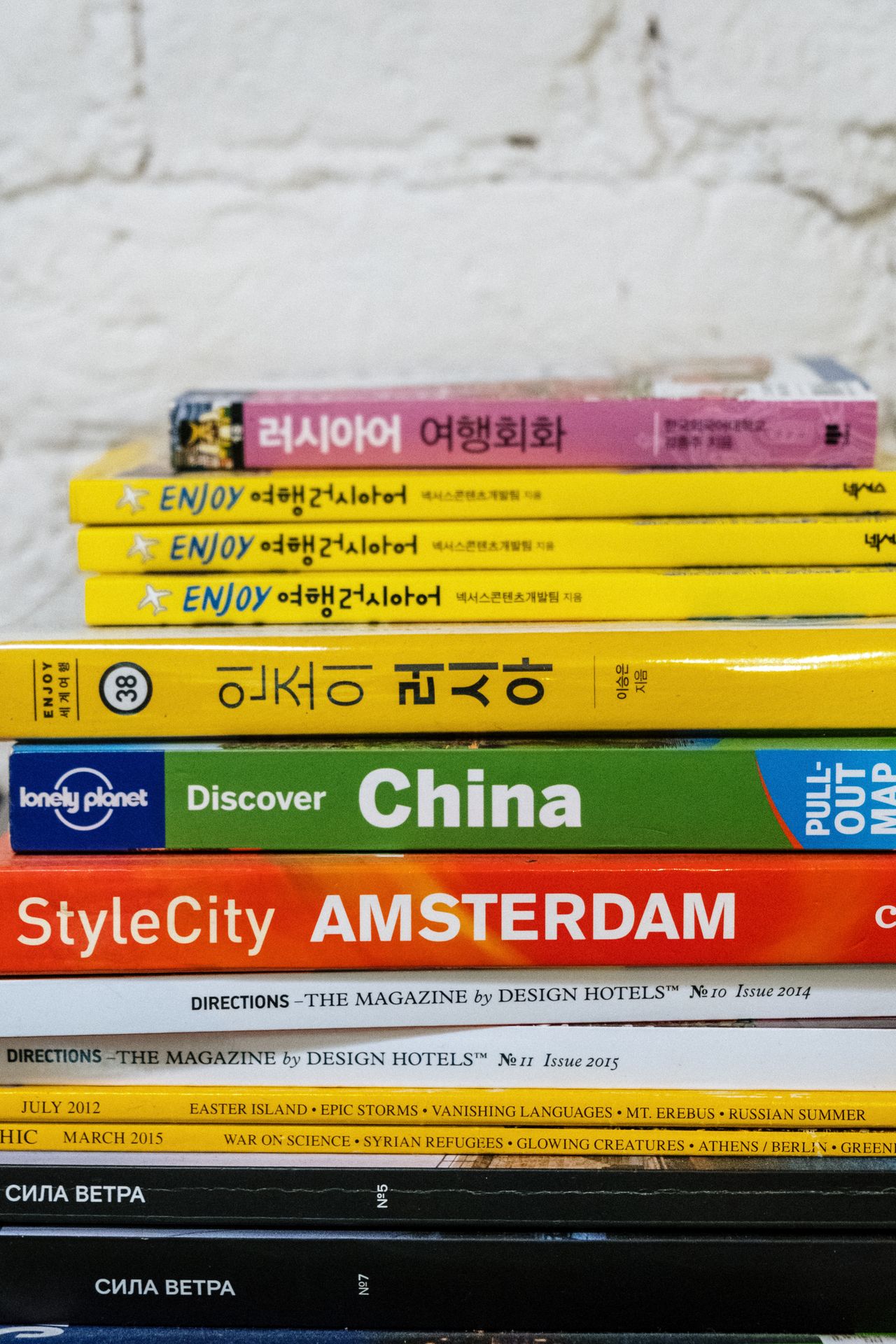 A colorful stack of travel guides and language books for global explorers