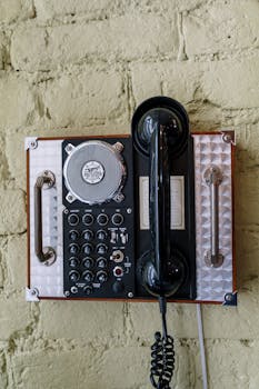 Classic wall-mounted analog telephone featuring retro design and control buttons.