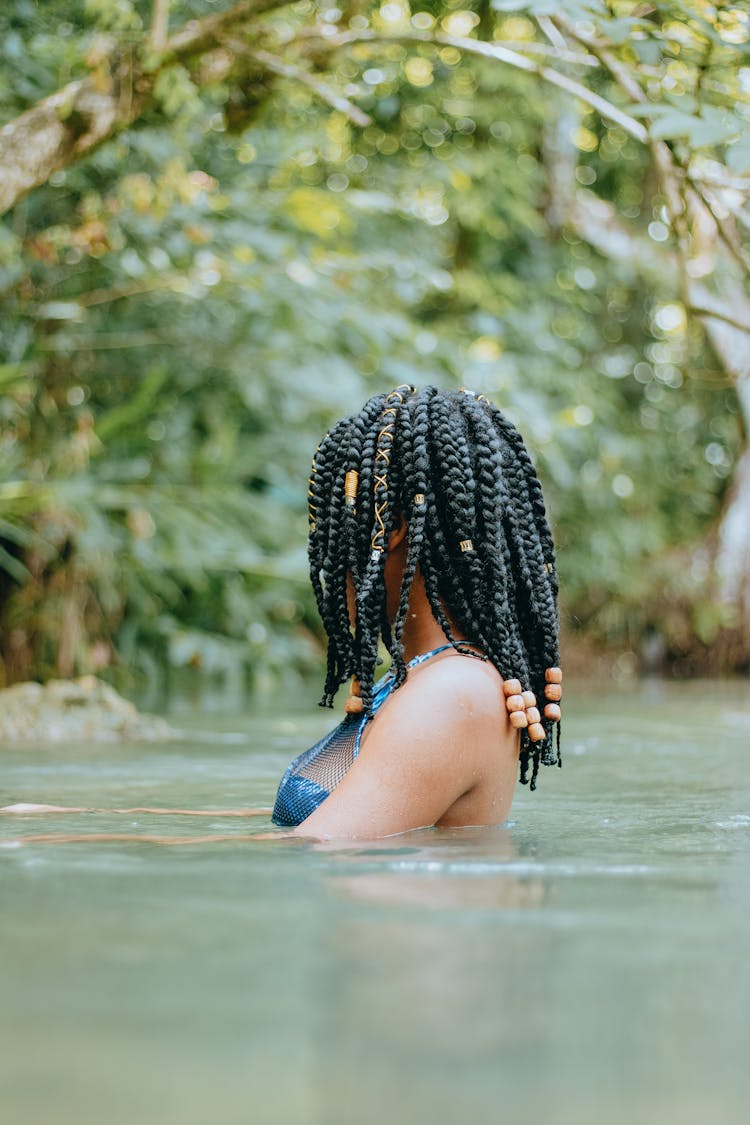 Unrecognizable Ethnic Traveler With Afro Braids Swimming In Pond