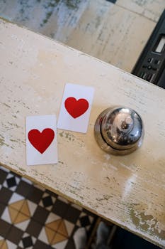 Charming setup with heart cards and a bell on a vintage table, perfect for Valentine's promotions.