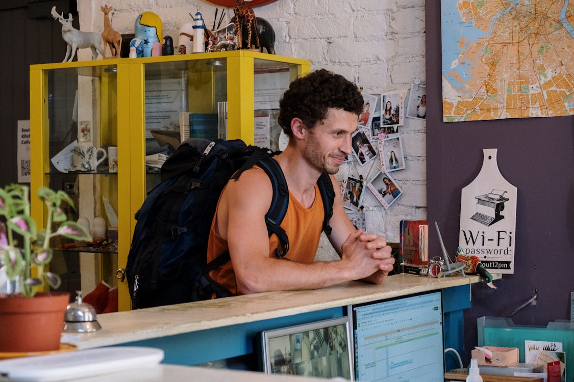 Free Man in Orange and Black Tank Top Sitting on Chair Stock Photo