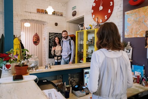 Free Backpackers Approaching Front Desk  Stock Photo