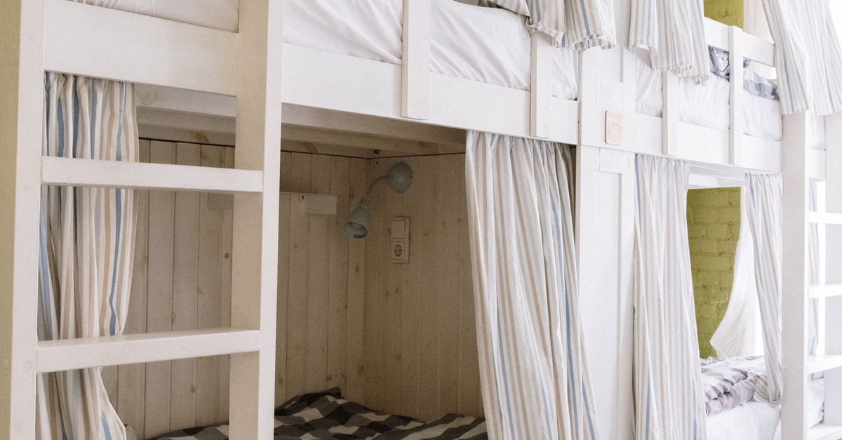 A modern dorm room featuring cozy bunk beds with privacy curtains and built-in storage.