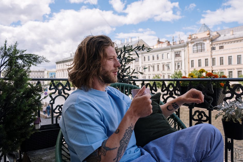 person enjoying coffee on apartment balcony - apartments with private balcony person enjoying coffee on apartment balcony - apartments with private balcony