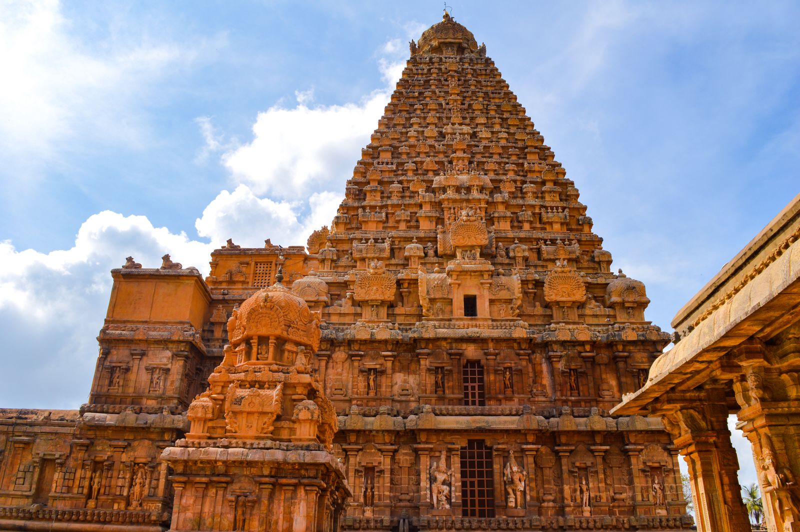 Ornate ancient Brihadeeswarar Temple tower in Tamil Nadu, India, against a blue sky
