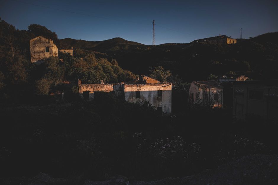 Vista atmosférica de edificios en decadencia en un paisaje rural de Cerdeña durante el crepúsculo.