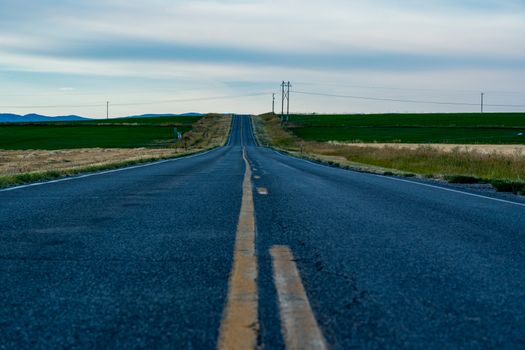 Peaceful rural road in Newton, Utah, surrounded by fields and open sky.