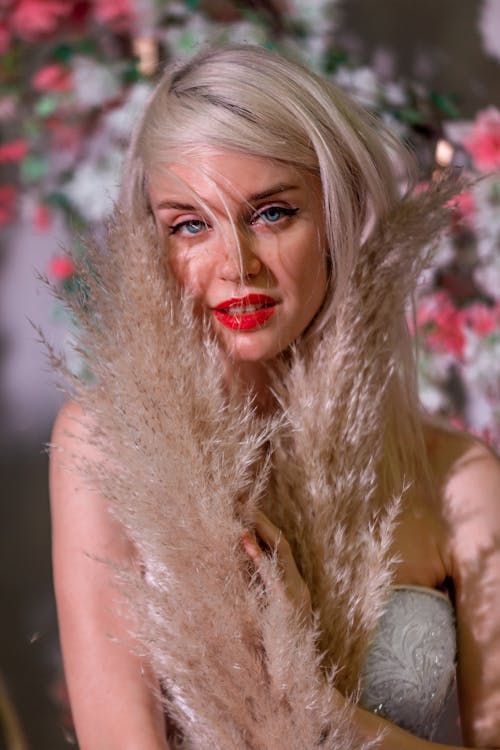 A Woman Posing while Holding a Pampas Grass 