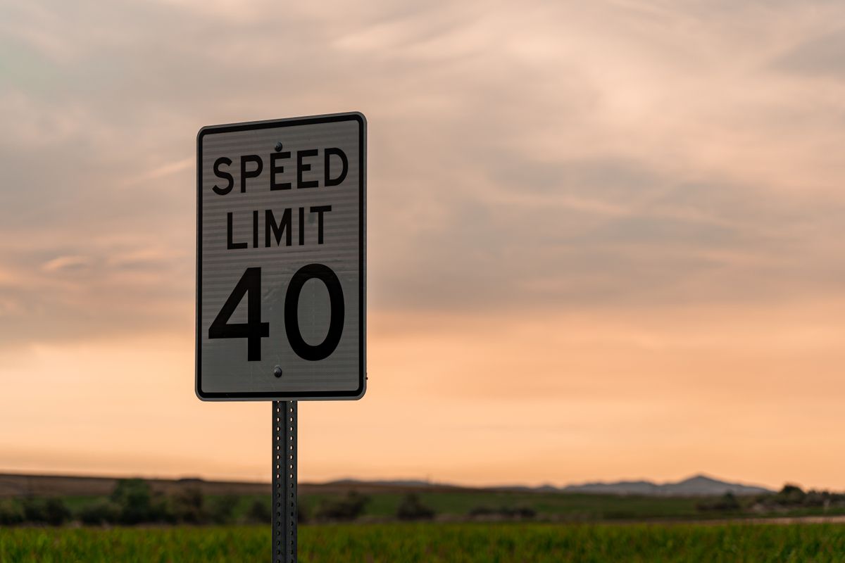 Love's Travel Stops: The Honest Guide to America's Favorite Road Trip Rest Stop 6 Empty American highway at dusk with a speed limit road sign and distant mountains